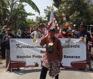 Pujimin Berfoto di depan Rombongan Pawai LDII Galur-Banaran dalam pawai kemerdekaan RI di Kapanewon Galur